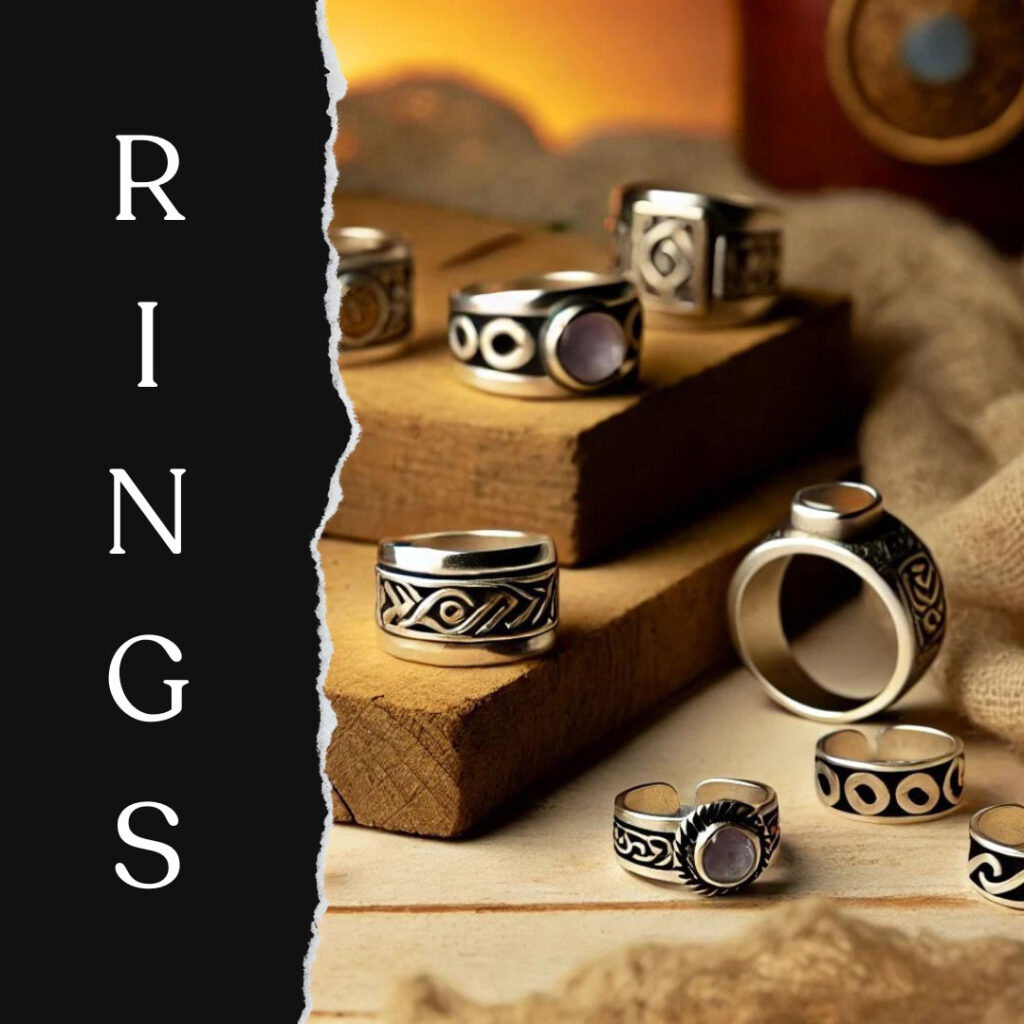 A close-up of intricate silver rings displayed on a wooden surface.